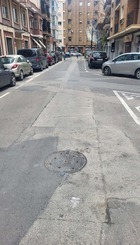 Calle parcheada y llena de baches